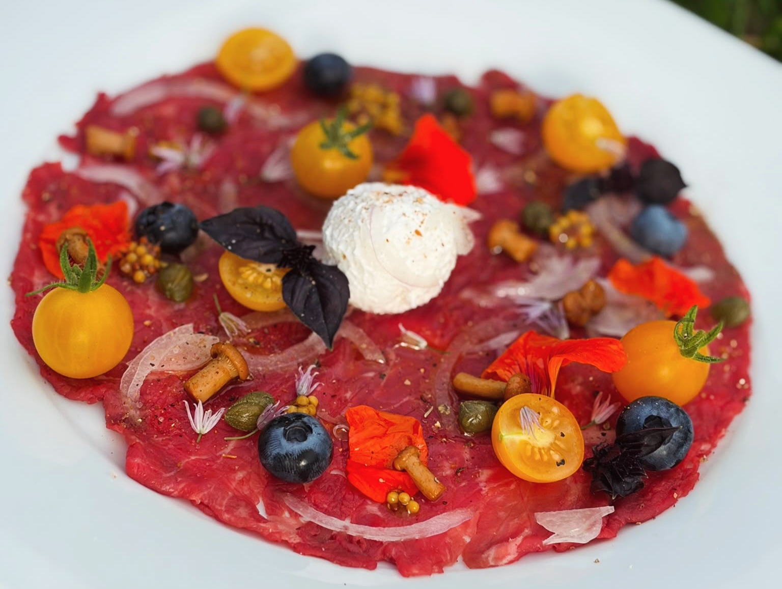 Rinder-Carpaccio mit Burrata, gelben Tomaten und essbaren Blüten – Fine-Dining für Firmenevents