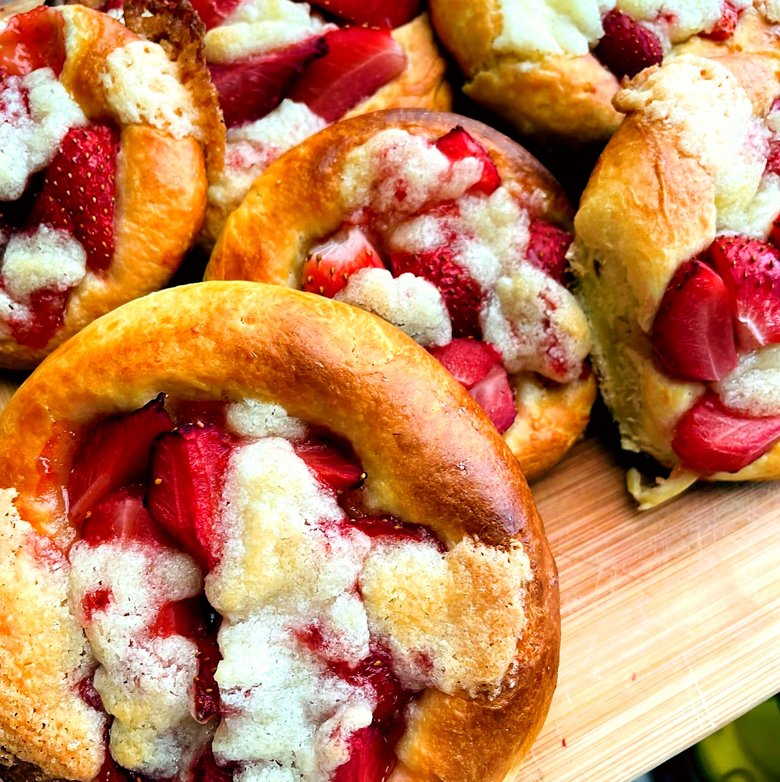 Frisch gebackene Erdbeer-Streuselschnecken auf Holzbrett – süßes Gebäck vom Catering Fritzi