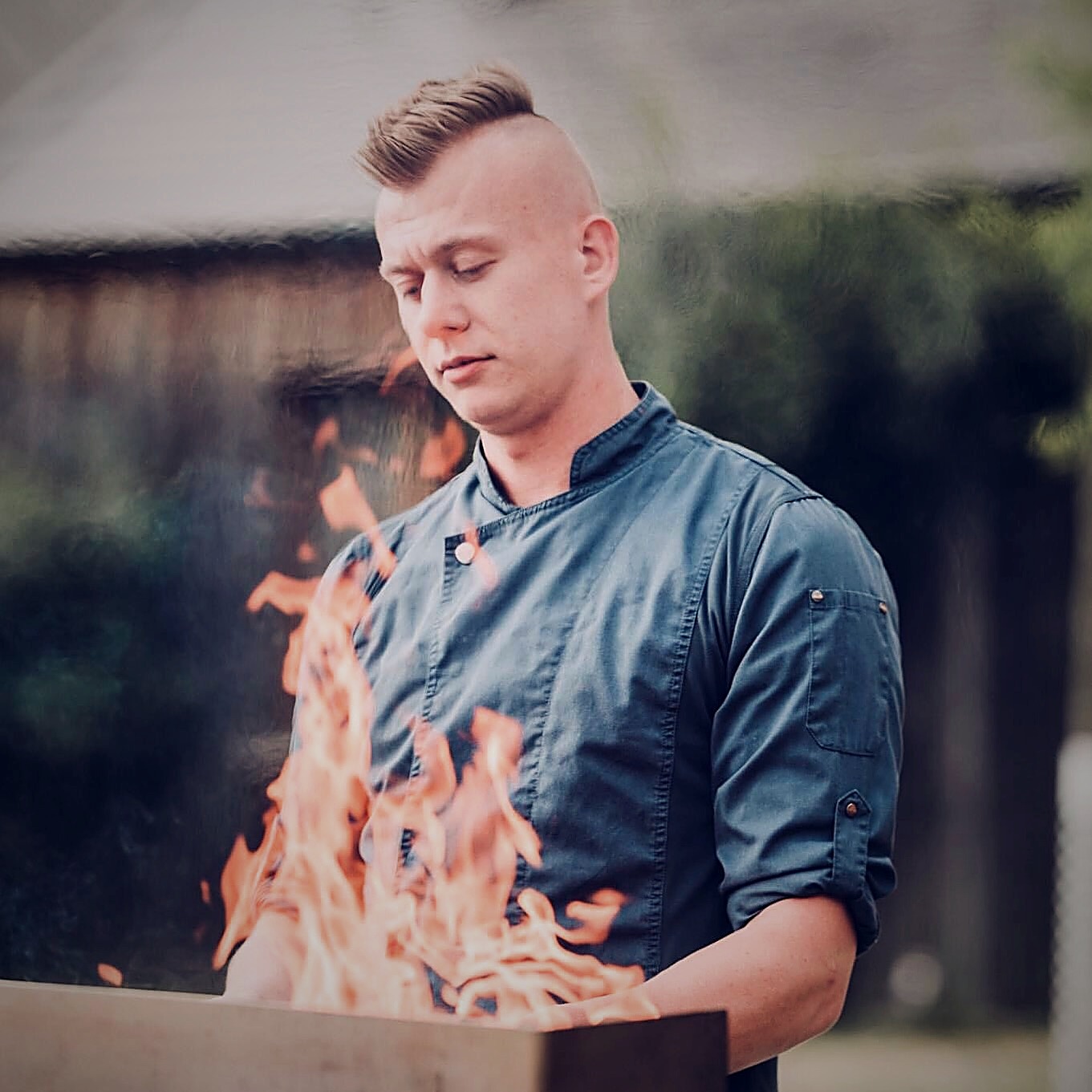 Privatkoch Fritzi kocht konzentriert über offenem Feuer – Live-Cooking für Events