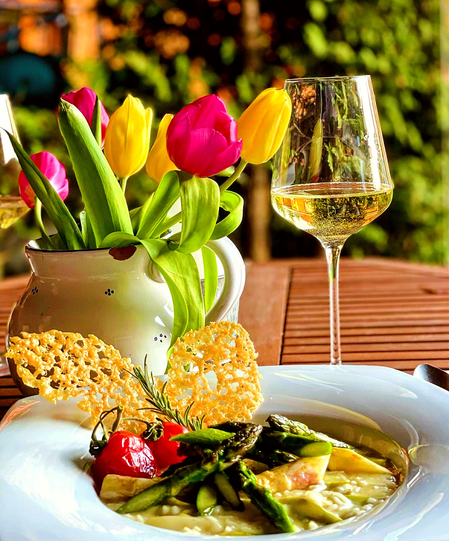 Gedeckter Gartentisch mit Spargelrisotto, Weißwein und Tulpen – Privatdinner mit Privatkoch Fritzi