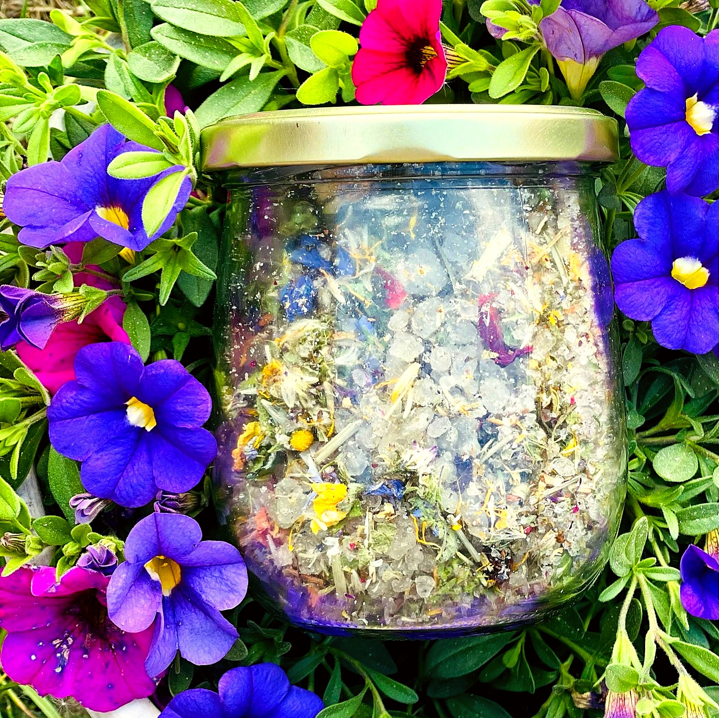 Glas mit selbstgemachtem Blütensalz zwischen lila Blüten – hausgemachte Produkte von Fritzi